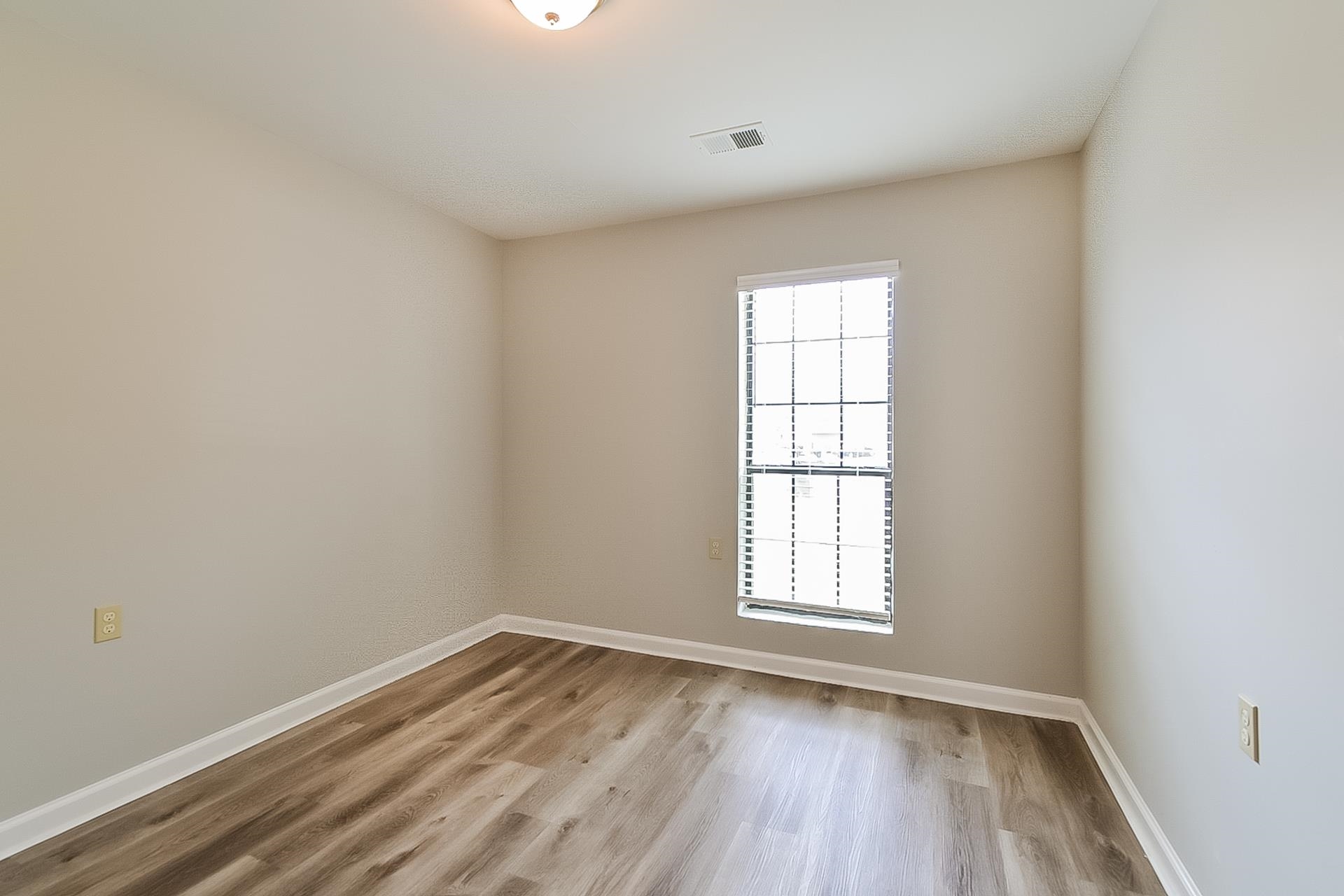 3890 Birchshade Cove Memphis, TN 38115 - Photo 12 of 16 an empty room with wooden floor and windows