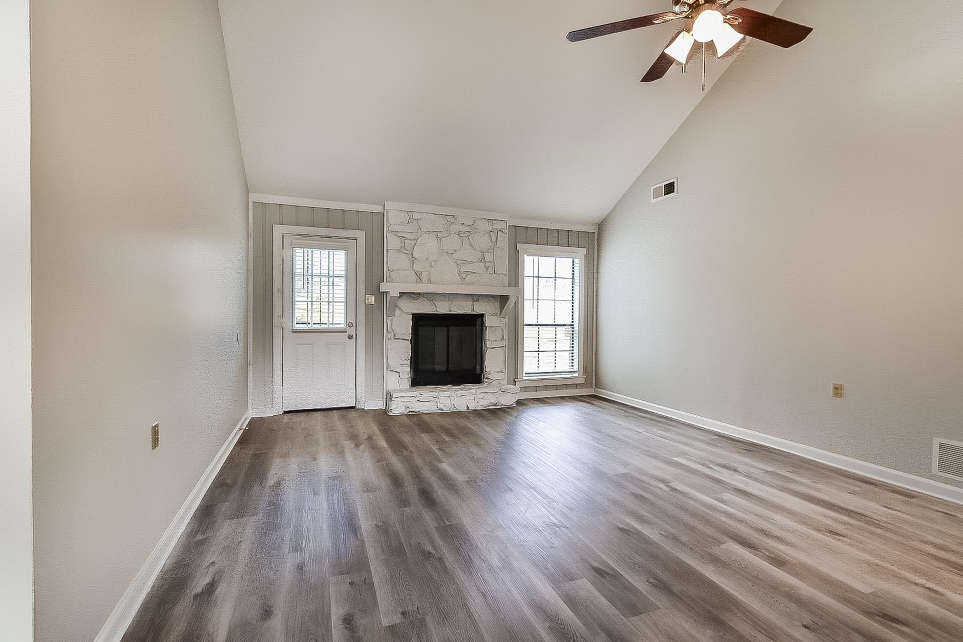3890 Birchshade Cove Memphis, TN 38115 - Photo 3 of 16 an empty room with wooden floor fireplace and windows