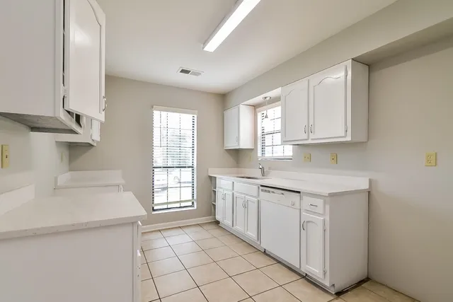 a kitchen with a sink cabinets appliances and a window