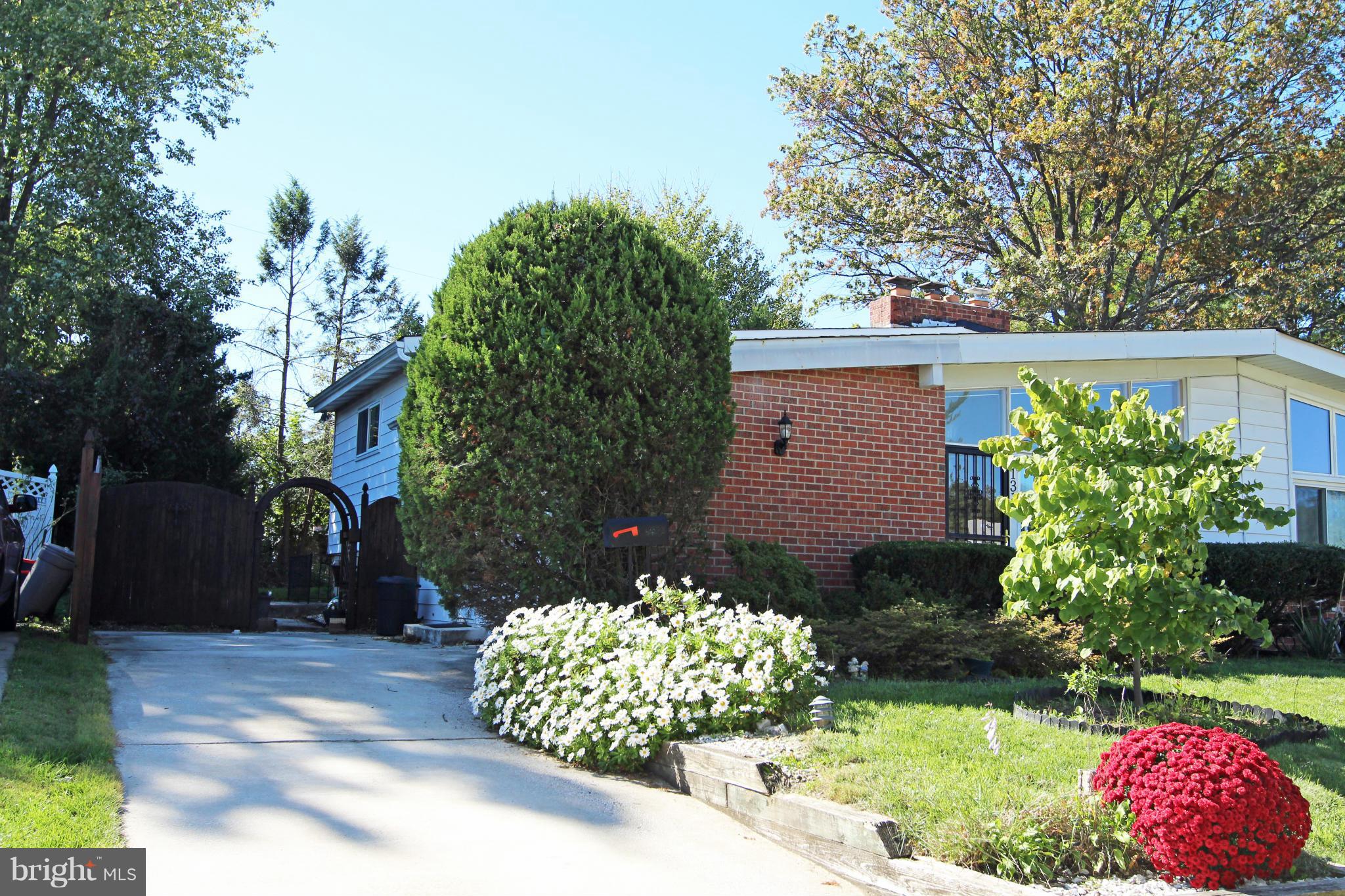 8131 Scotts Level Road Baltimore, MD 21208 - Photo 1 of 29 a front view of a house with a yard and a garden