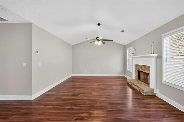 a view of empty room with wooden floor and fireplace