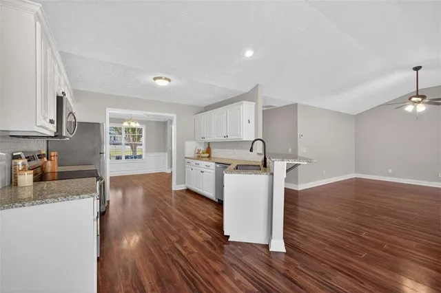 a kitchen with wooden floors and white cabinets