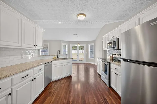 a kitchen with white cabinets and stainless steel appliances