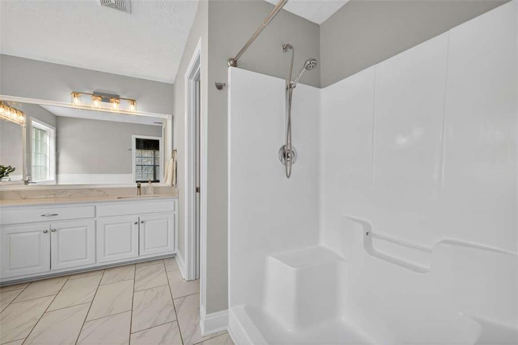 70 Tysor Court Jefferson, GA 30549 - Photo 30 of 50 a spacious bathroom with a granite countertop sink mirror and shower