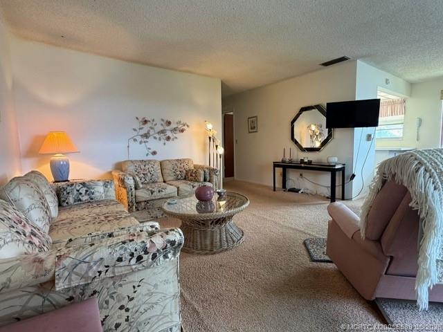 2929 Southeast Ocean Boulevard, Unit 1306 Stuart, FL 34996 - Photo 5 of 17 a living room with furniture a rug and a fireplace