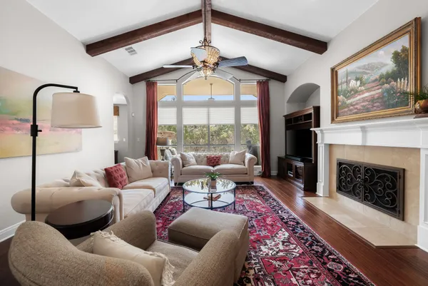 a living room with furniture a fireplace and a floor to ceiling window