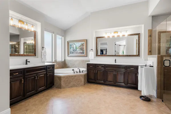 a spacious bathroom with a tub sink and mirror