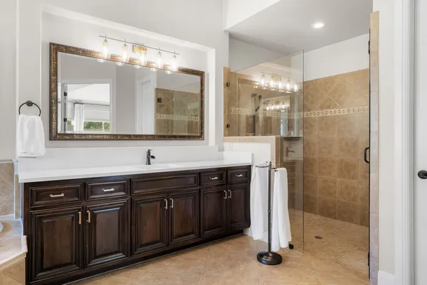 a bathroom with a double vanity sink a large mirror and a shower