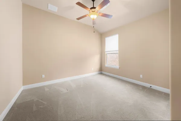 an empty room with a window and a fan