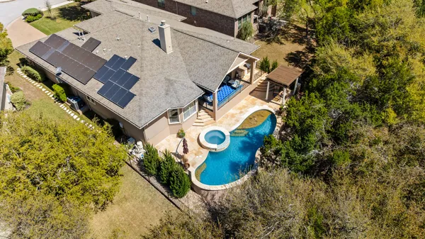 an aerial view of a house with swimming pool and outdoor space