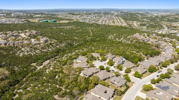 an aerial view of residential houses with outdoor space and trees