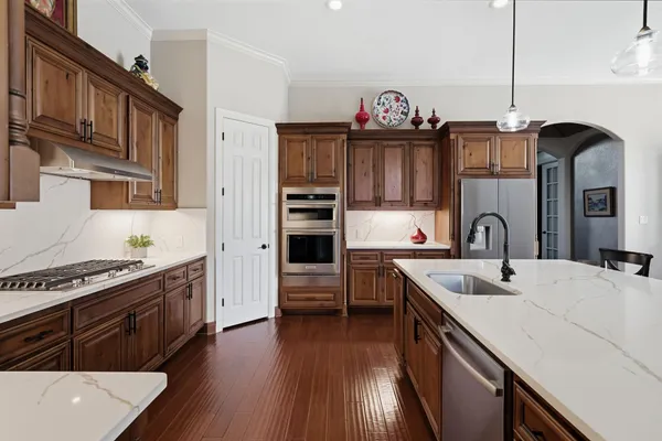 a kitchen with kitchen island granite countertop a stove and a sink