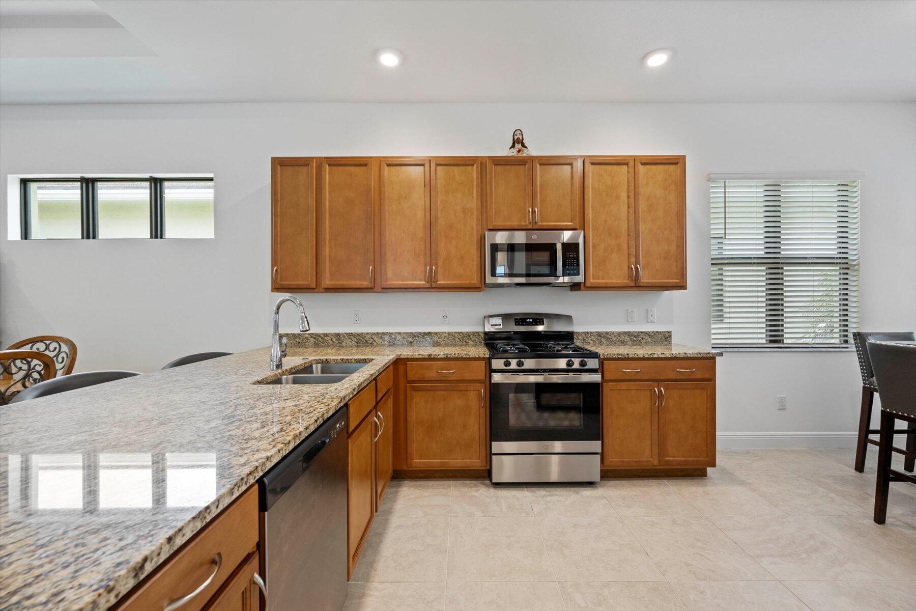 5409 Santa Rosa Lane Westlake, FL 33470 - Photo 6 of 51 a kitchen with stainless steel appliances granite countertop a stove a sink a microwave a refrigerator and cabinets
