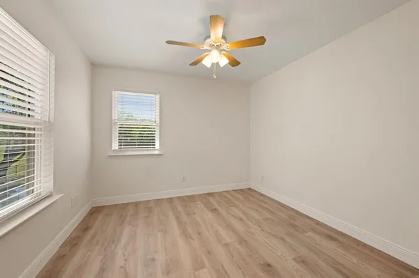 an empty room with a window and a fan