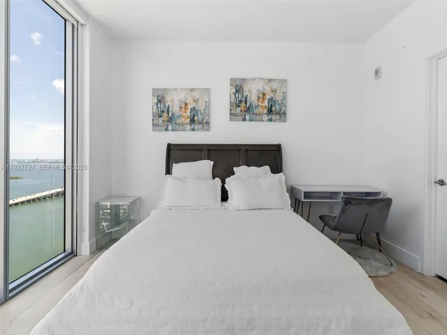 a bedroom with a bed and a painting on the wall