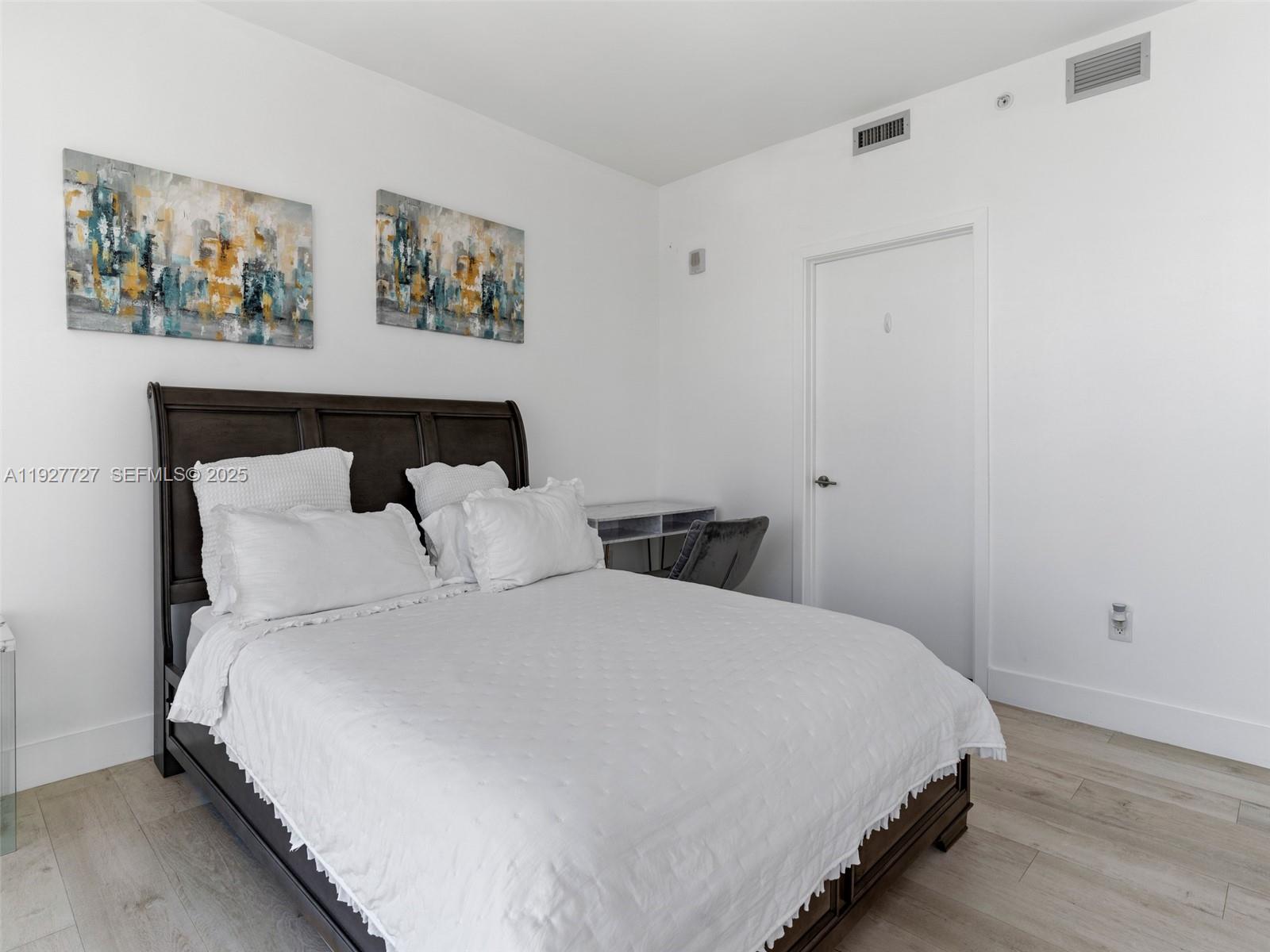 2900 Northeast 7th Avenue, Unit 4301 Miami, FL 33137 - Photo 12 of 24 a large bed sitting in a bedroom next to a wall with a painting on the wall