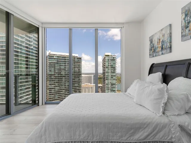 a bedroom with a large bed and a large window