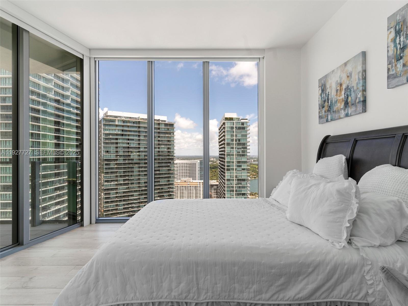 2900 Northeast 7th Avenue, Unit 4301 Miami, FL 33137 - Photo 13 of 24 a bedroom with a large bed and a large window