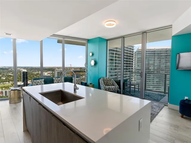 a view of kitchen island a sink a counter space and living room