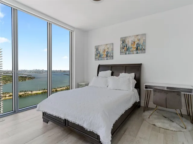 a large bed sitting in a bedroom next to a window