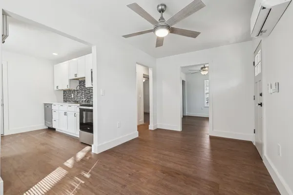 a view of a kitchen with wooden floor and a ceiling fan