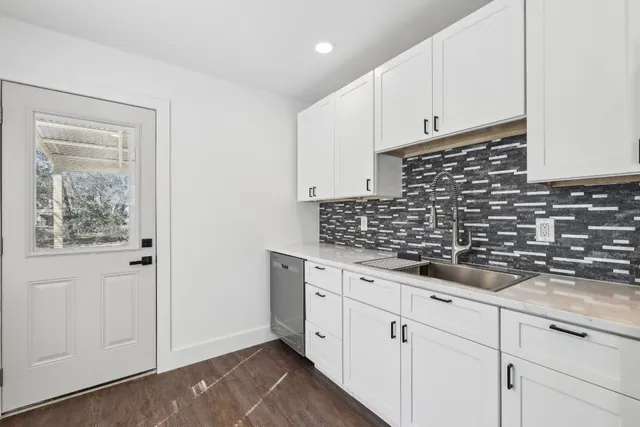a kitchen with granite countertop white cabinets and white appliances