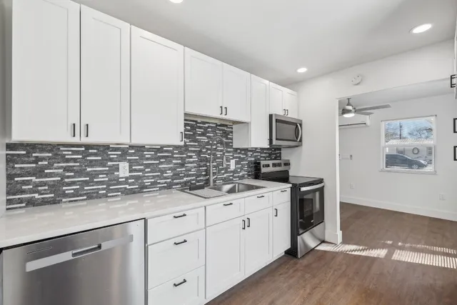 a kitchen with stainless steel appliances granite countertop a sink stove and refrigerator