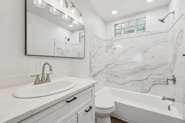 a bathroom with a sink a toilet and bathtub