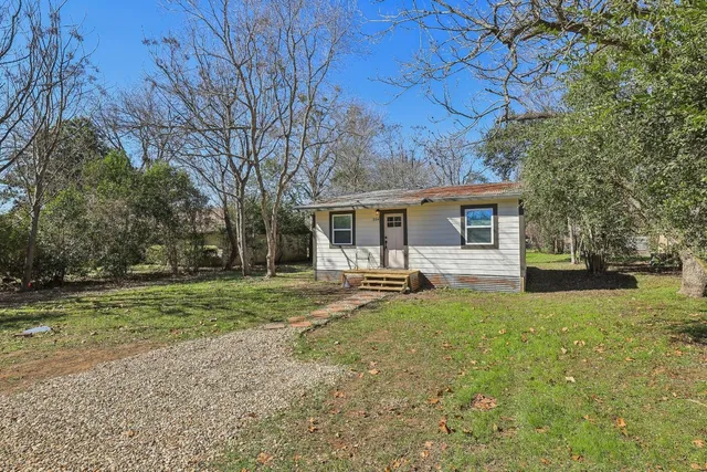 a view of a house with backyard and sitting area