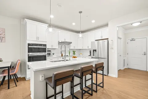 a kitchen with kitchen island a stove a table and chairs in it