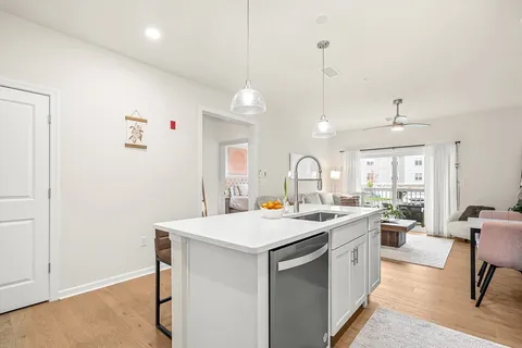 a room with a sink a stove a couch and chairs