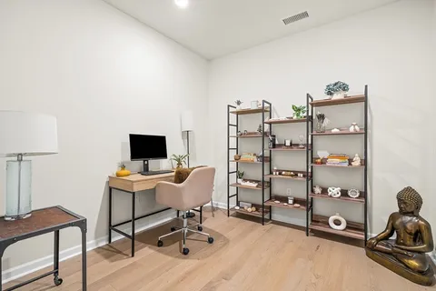 a view of a workspace with furniture and a window