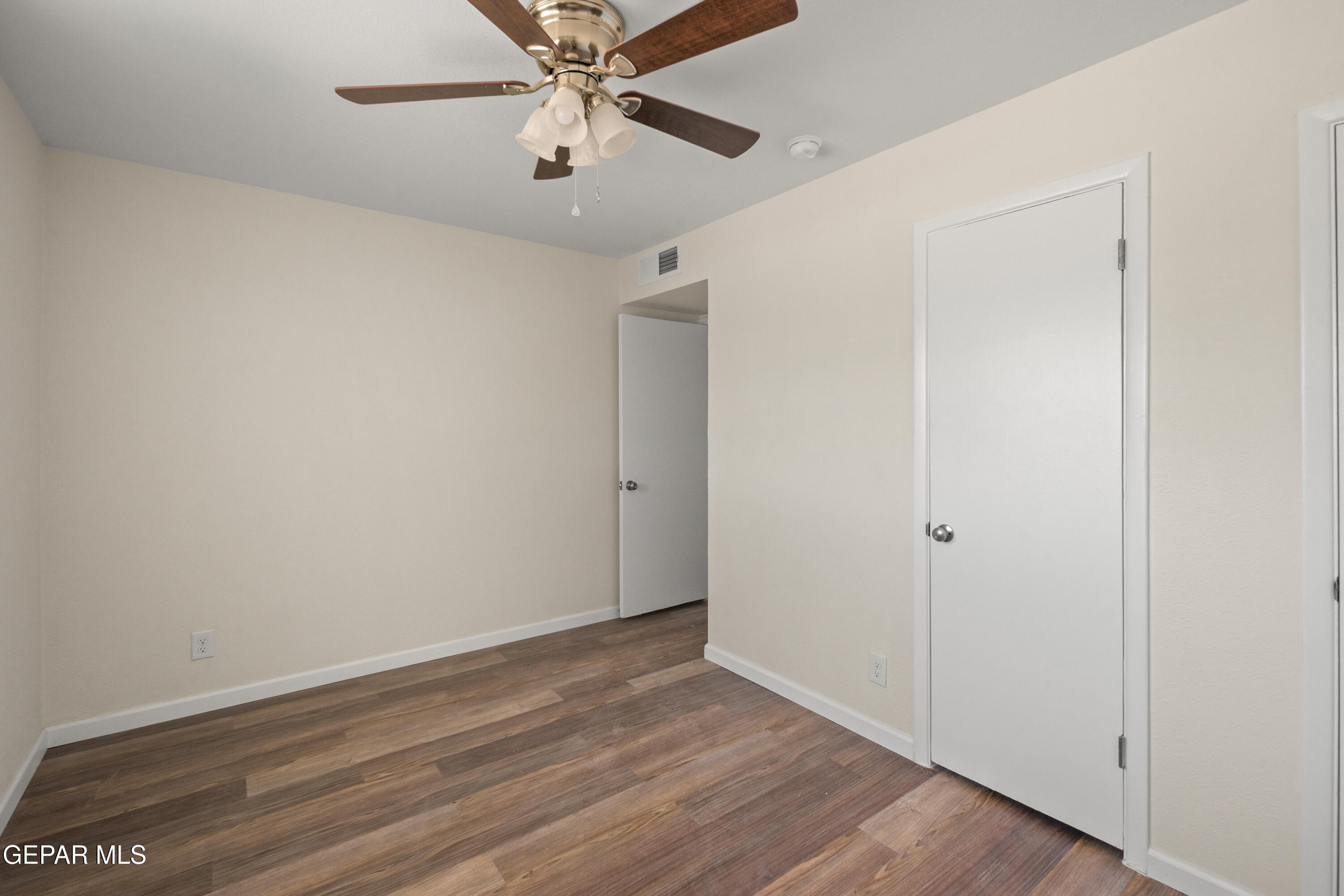 9220 Raleigh Drive El Paso, TX 79924 - Photo 12 of 23 an empty room with wooden floor closet and fan chandelier fan