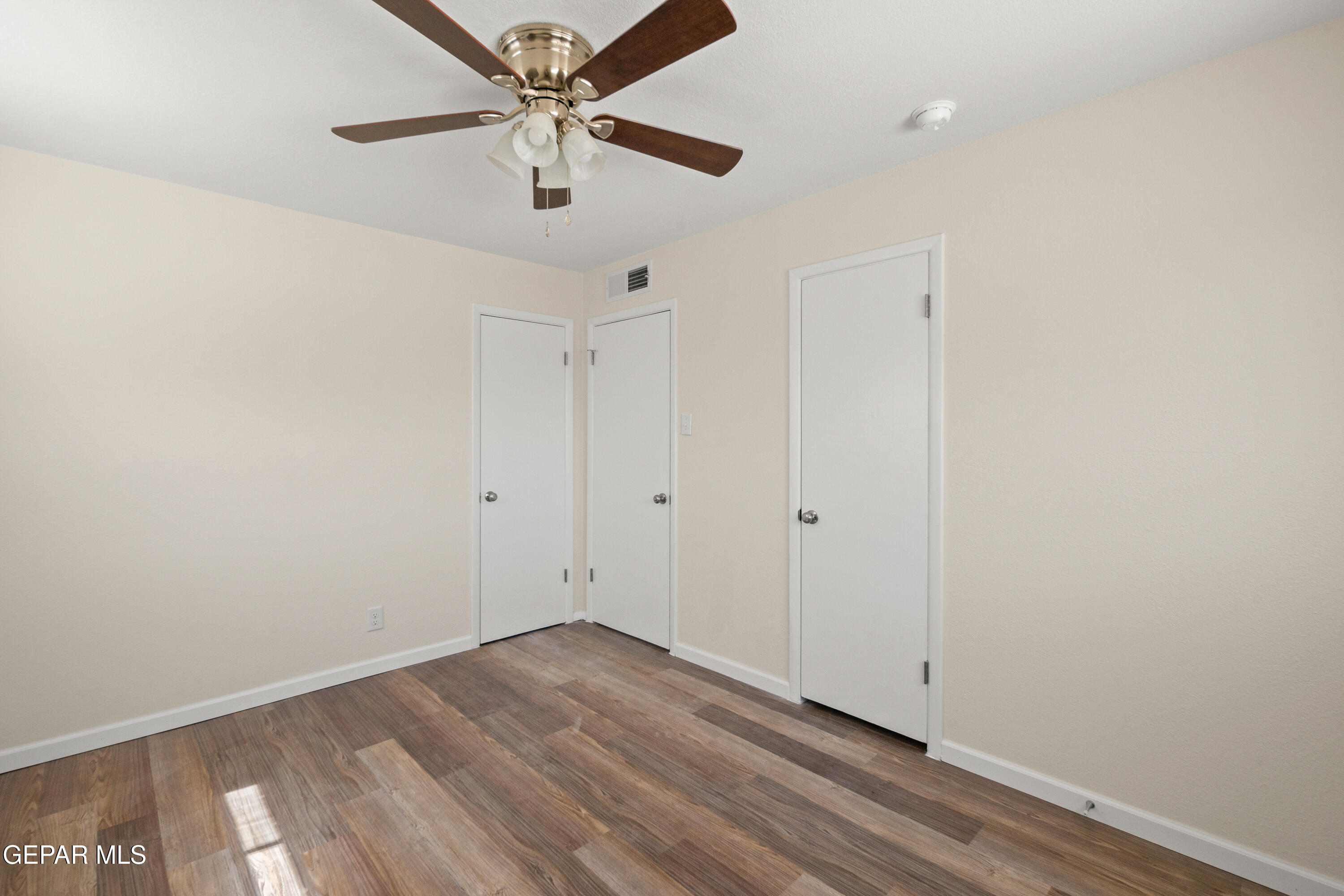 9220 Raleigh Drive El Paso, TX 79924 - Photo 15 of 23 an empty room with wooden floor and ceiling fan