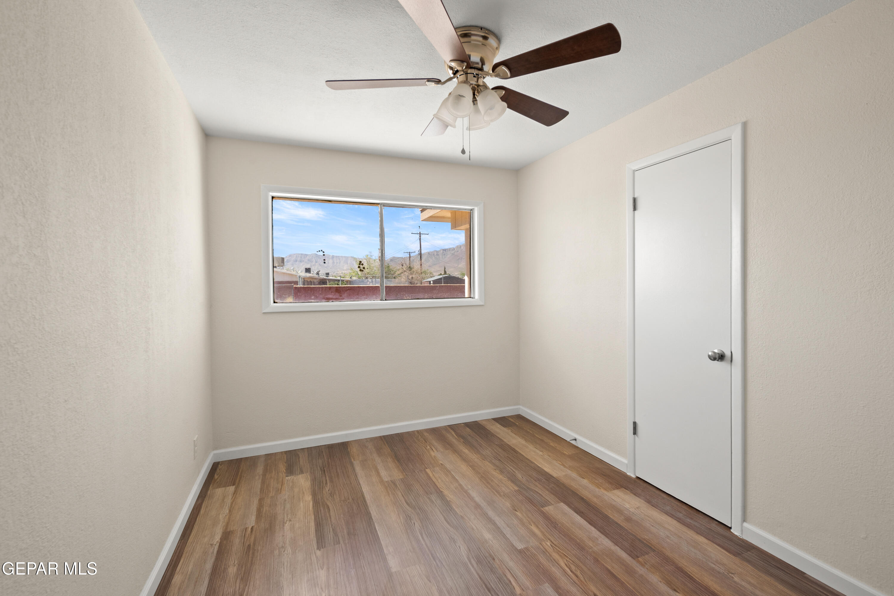 9220 Raleigh Drive El Paso, TX 79924 - Photo 9 of 23 an empty room with a window and a ceiling fan