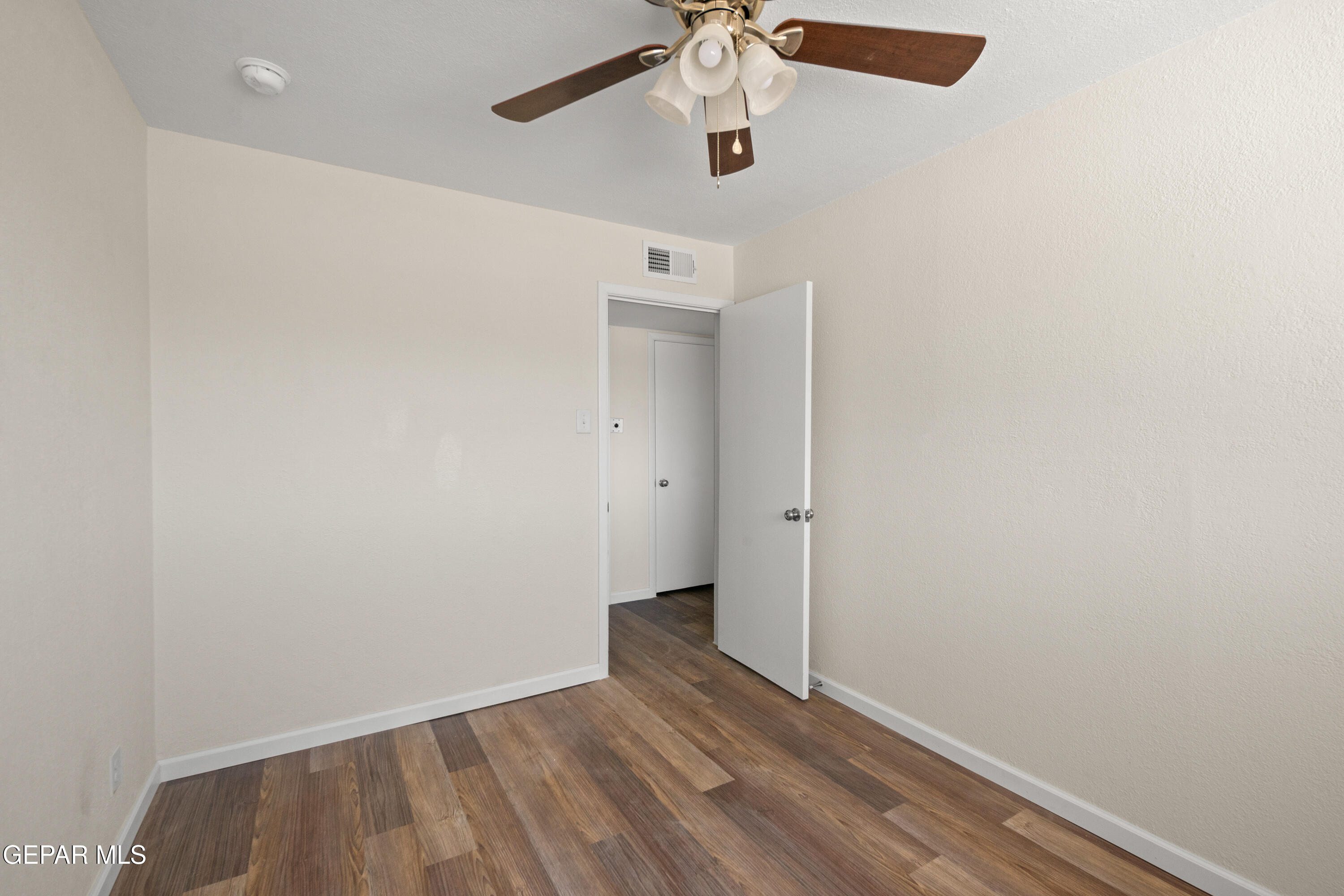 9220 Raleigh Drive El Paso, TX 79924 - Photo 10 of 23 an empty room with wooden floor ceiling fan and window