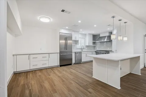 a kitchen with stainless steel appliances a refrigerator sink and white cabinets