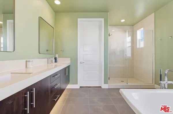 a bathroom with a tub sink and mirror