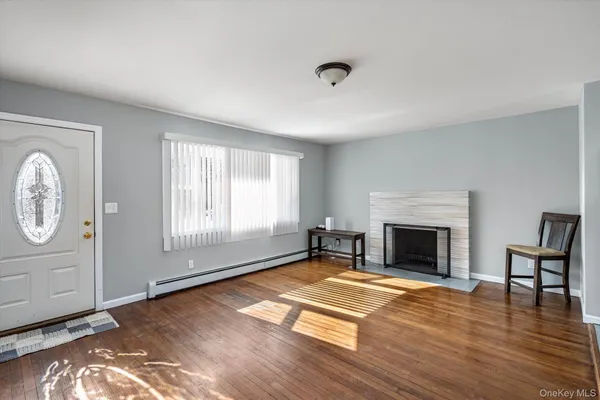 a view of empty room with wooden floor and fireplace
