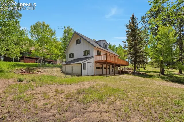 a view of a house with a yard and large trees