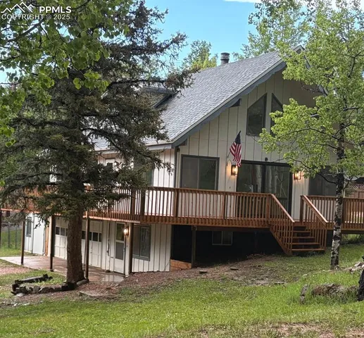 a view of a house with a deck and a yard