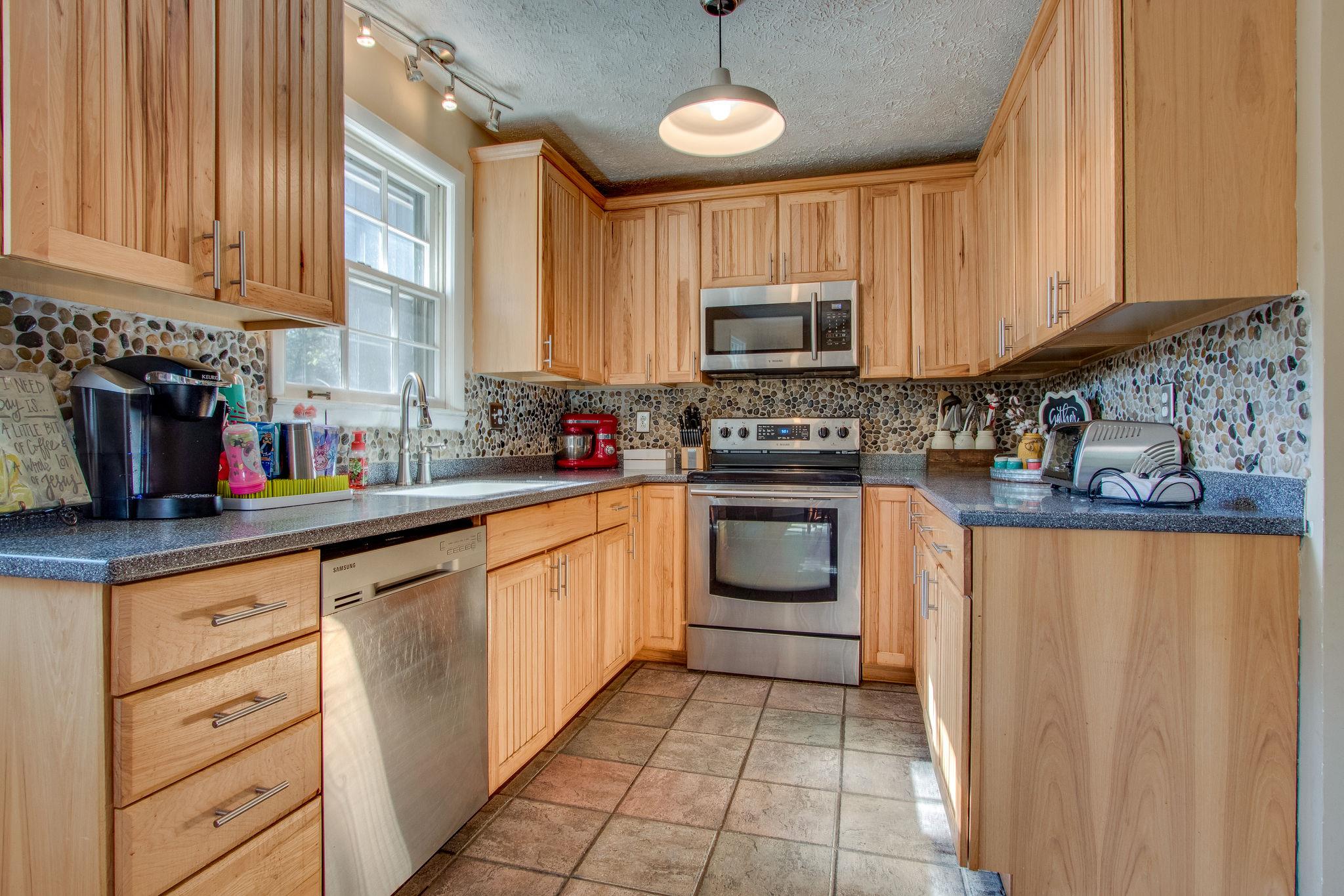 835 Beasleys Bend Road Lebanon, TN 37087 - Photo 14 of 33 a kitchen with stainless steel appliances granite countertop a stove sink microwave and cabinets