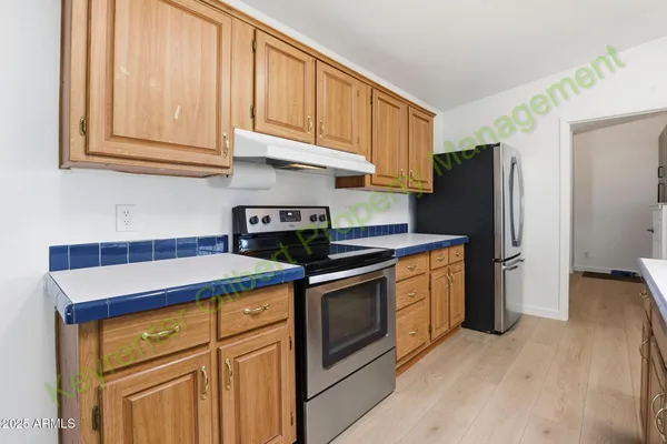 a kitchen with stainless steel appliances granite countertop a stove top oven a sink dishwasher and cabinets with wooden floor