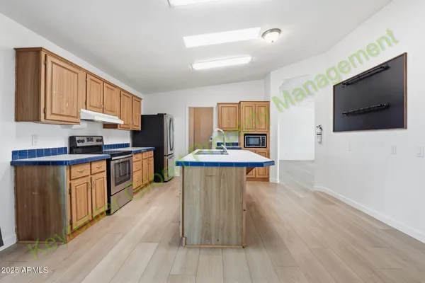 a kitchen with granite countertop a refrigerator and a stove top oven