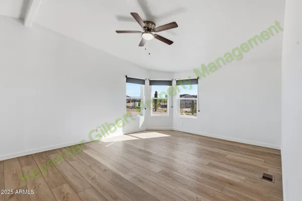 a view of a livingroom with wooden floor and a ceiling fan