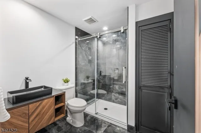 a bathroom with a shower a toilet and a sink