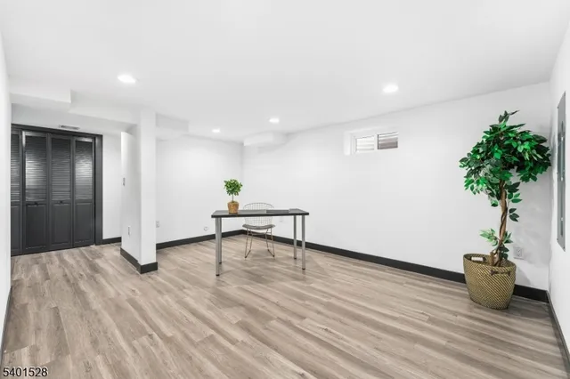 a view of a livingroom with wooden floor and a potted plant