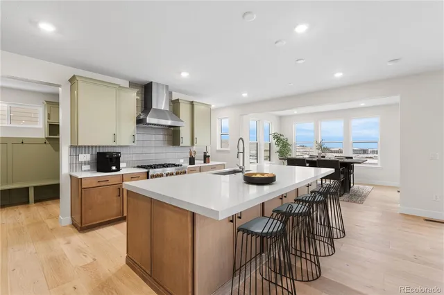 a kitchen with a stove a sink a kitchen island with a dining table and chairs