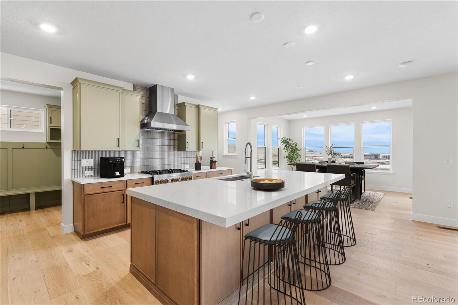 11303 Tenor Trail Lone Tree, CO 80134 - Photo 11 of 49 a kitchen with a stove a sink a kitchen island with a dining table and chairs