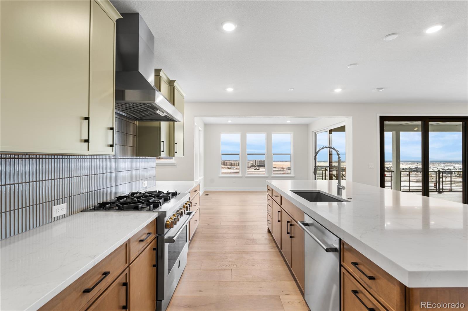 11303 Tenor Trail Lone Tree, CO 80134 - Photo 12 of 49 a large kitchen with stainless steel appliances a large counter top a stove and a sink